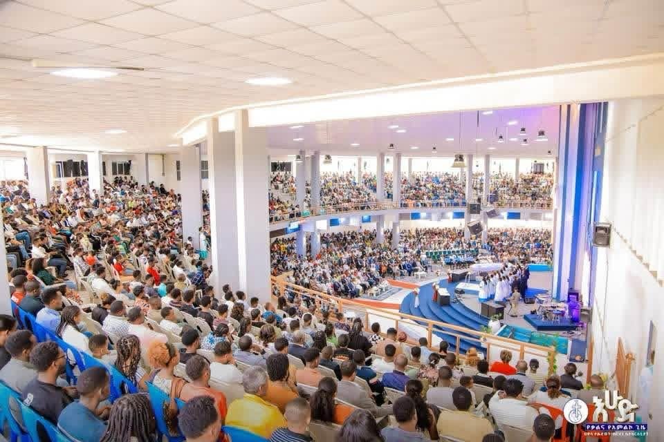 Congregation gathered inside a bright, two-level church hall.
